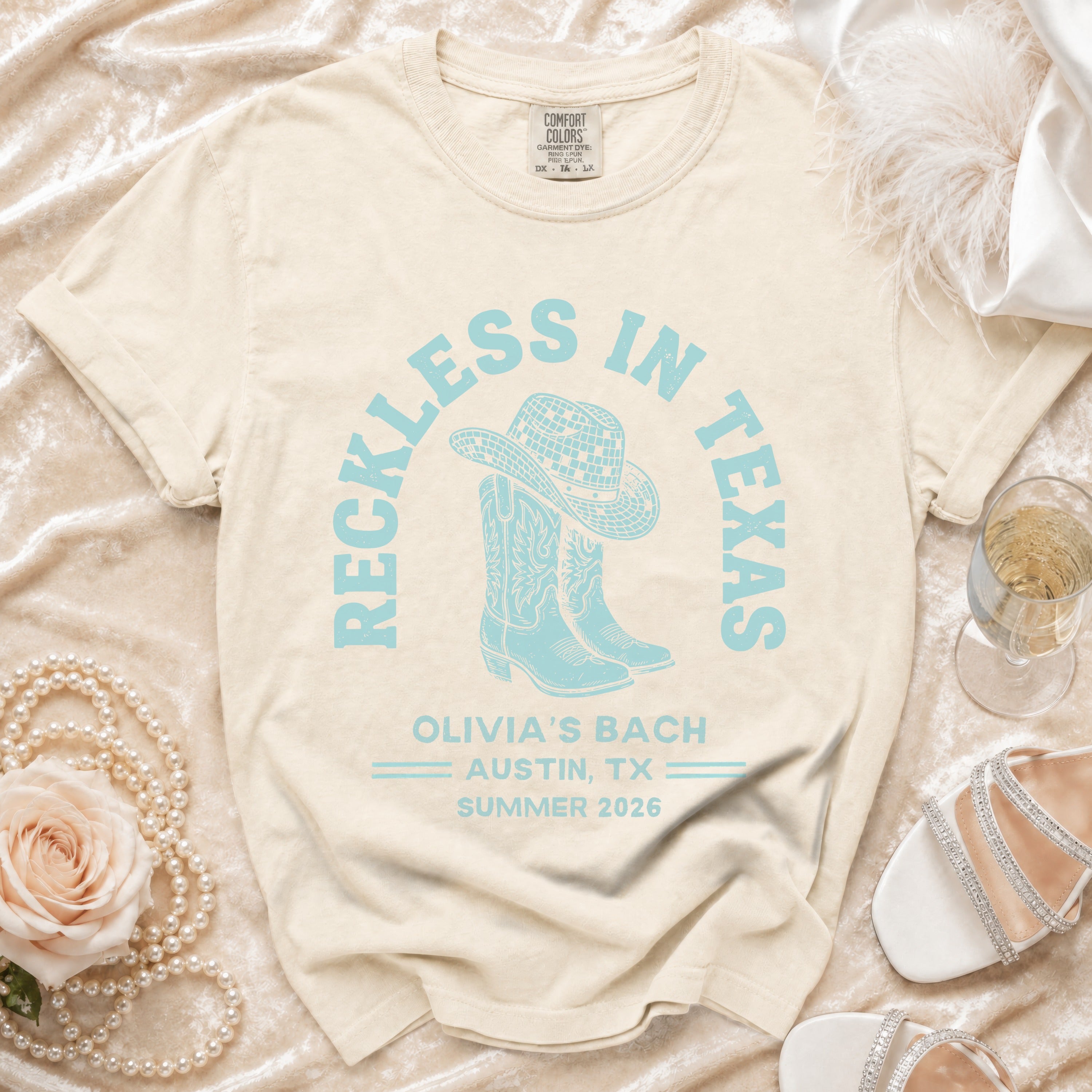 Cream t-shirt with "Reckless in Texas" and "Olivia's Bach Austin, TX Summer 2026".