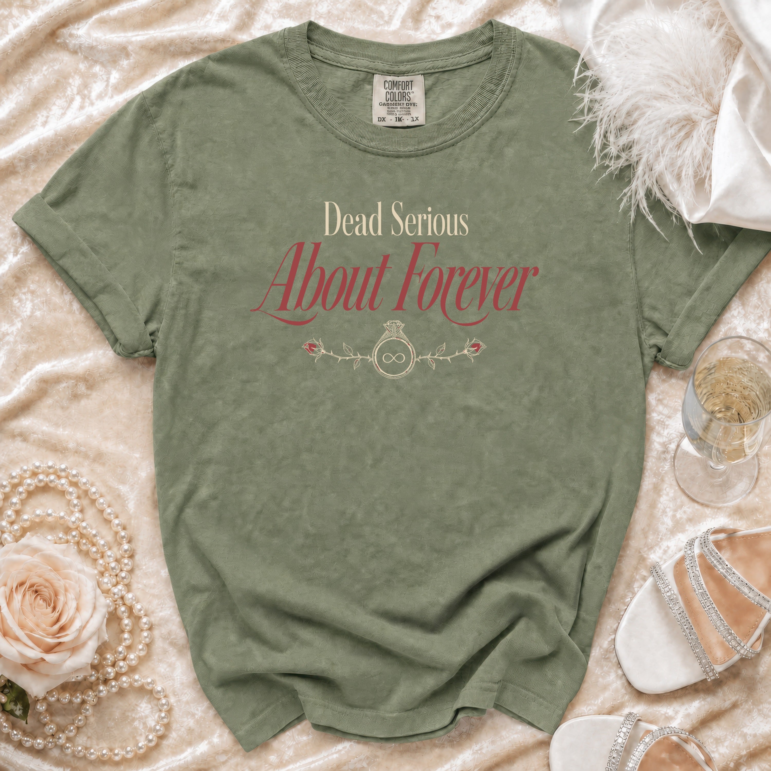 Olive green t-shirt with "Dead Serious About Forever" text and rose/infinity ring design.