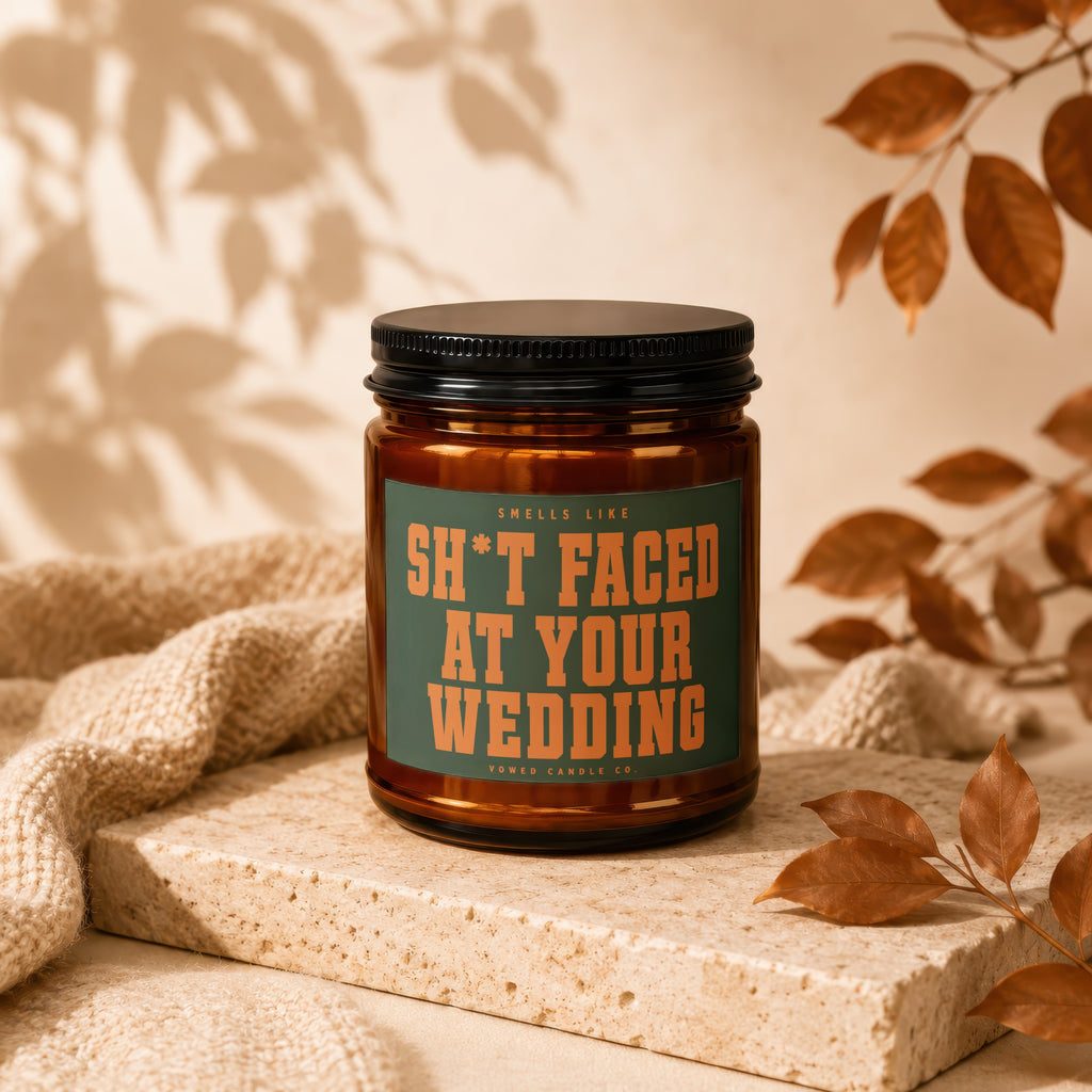 Brown glass candle with "SH*T FACED AT YOUR WEDDING" text.