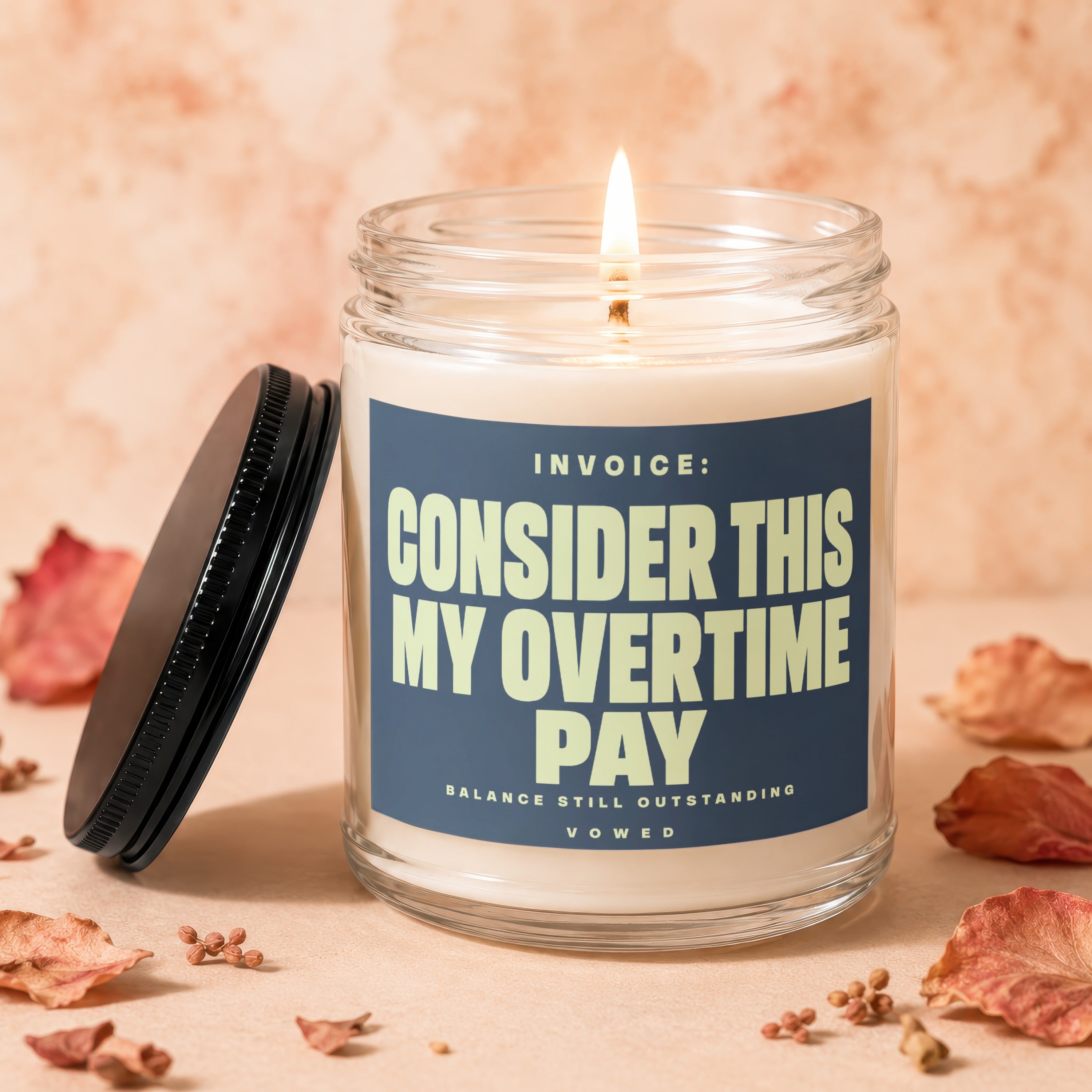 Jar candle with blue label: "INVOICE: CONSIDER THIS MY OVERTIME PAY"