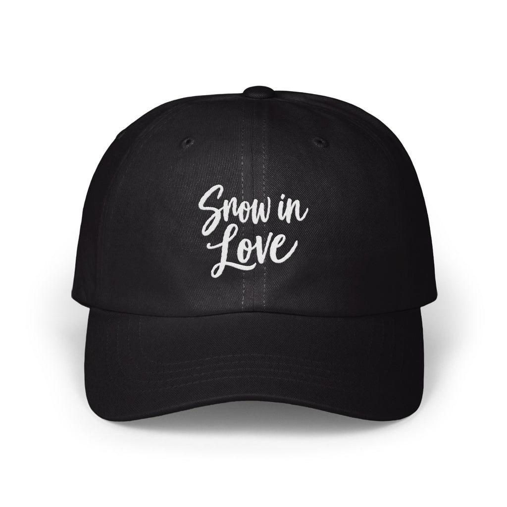 A black dad hat features the white embroidered text Snow in Love centered on the front panels.