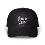 A black dad hat features the white embroidered text Snow in Love centered on the front panels.