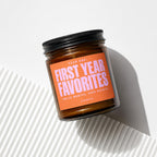 Amber jar candle with orange label reading "Year One: First Year Favorites"