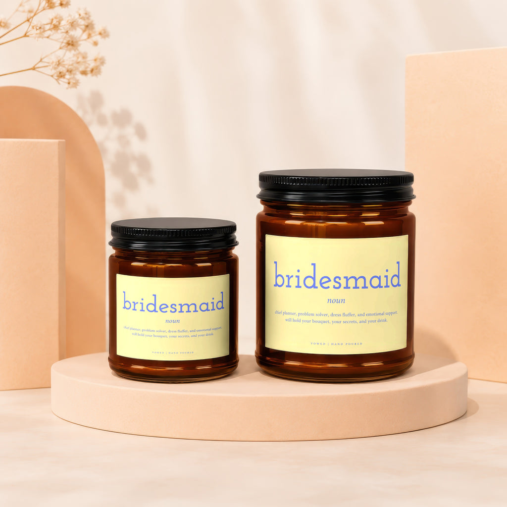 Two amber glass candles with yellow labels reading "bridesmaid" and its definition.