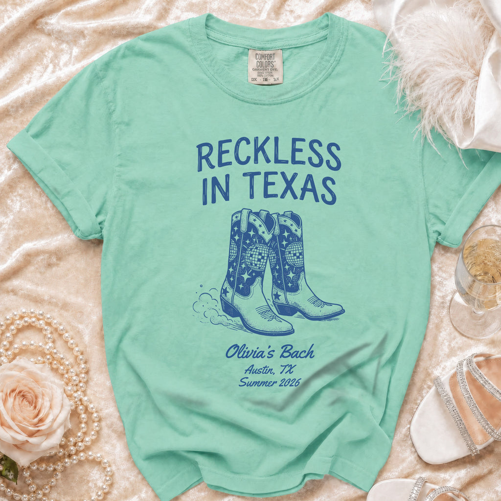 Green t-shirt with "Reckless In Texas" and cowboy boots design.