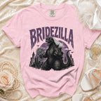 Pink t-shirt with "Bridezilla" text and Godzilla wearing a veil and heart sunglasses.