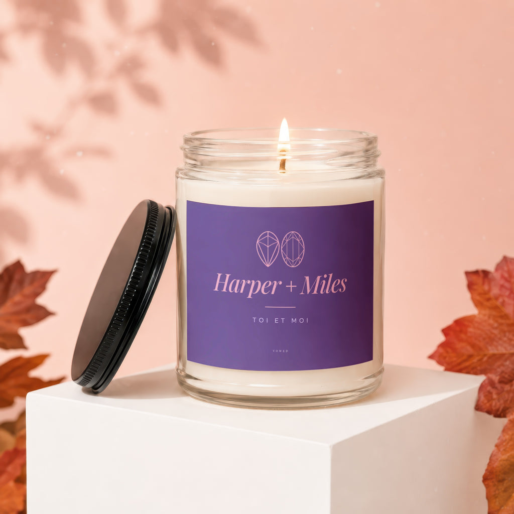 Harper + Miles candle with purple label, lit flame, and lid off.
