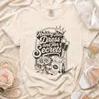 Cream t-shirt with "Holding Her Dress and Her Secrets" graphic.