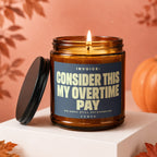 Amber jar candle lit, with label: "Invoice: Consider this my overtime pay".