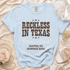 Light blue Comfort Colors t-shirt with "Reckless in Texas Olivia's Bach Austin, TX Summer 2026" text.
