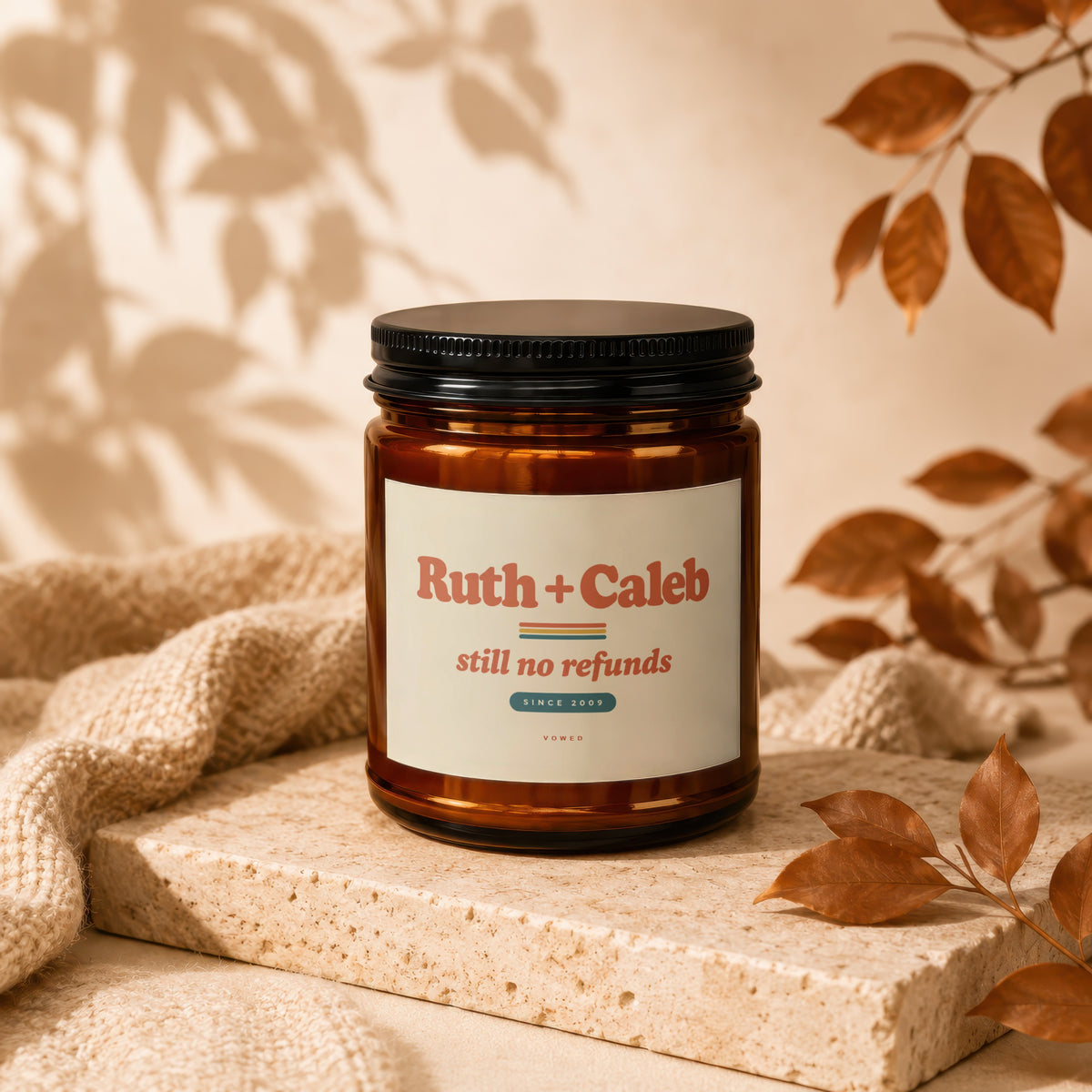 Amber jar candle with black lid, "Ruth + Caleb still no refunds SINCE 2009" label.