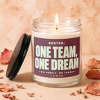 Glass candle with lit wick and label: "ROSTER: ONE TEAM, ONE DREAM. TWO PEOPLE. NO TRADES. VOWED."