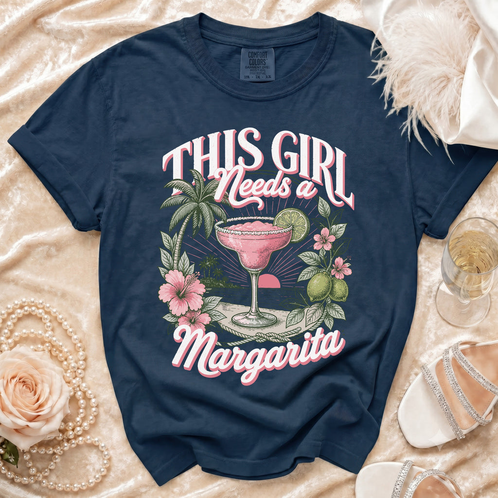 Navy Comfort Colors t-shirt with "This Girl Needs a Margarita" graphic and tropical scene.