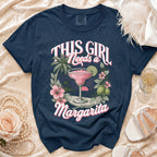 Navy Comfort Colors t-shirt with "This Girl Needs a Margarita" graphic and tropical scene.