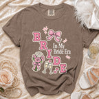 Brown t-shirt with "Bride In My Bride Era" graphic and wedding elements.