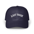 Navy blue baseball cap with white embroidered text "LAST TOAST".