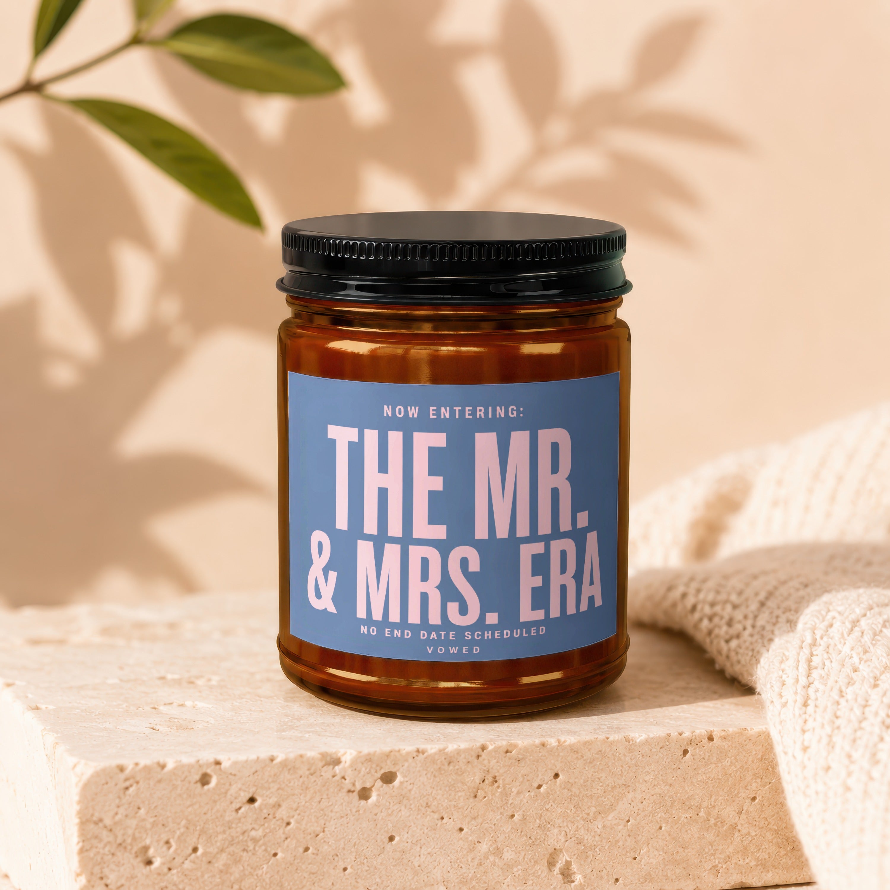 Candle with blue label reading "The Mr. & Mrs. Era."