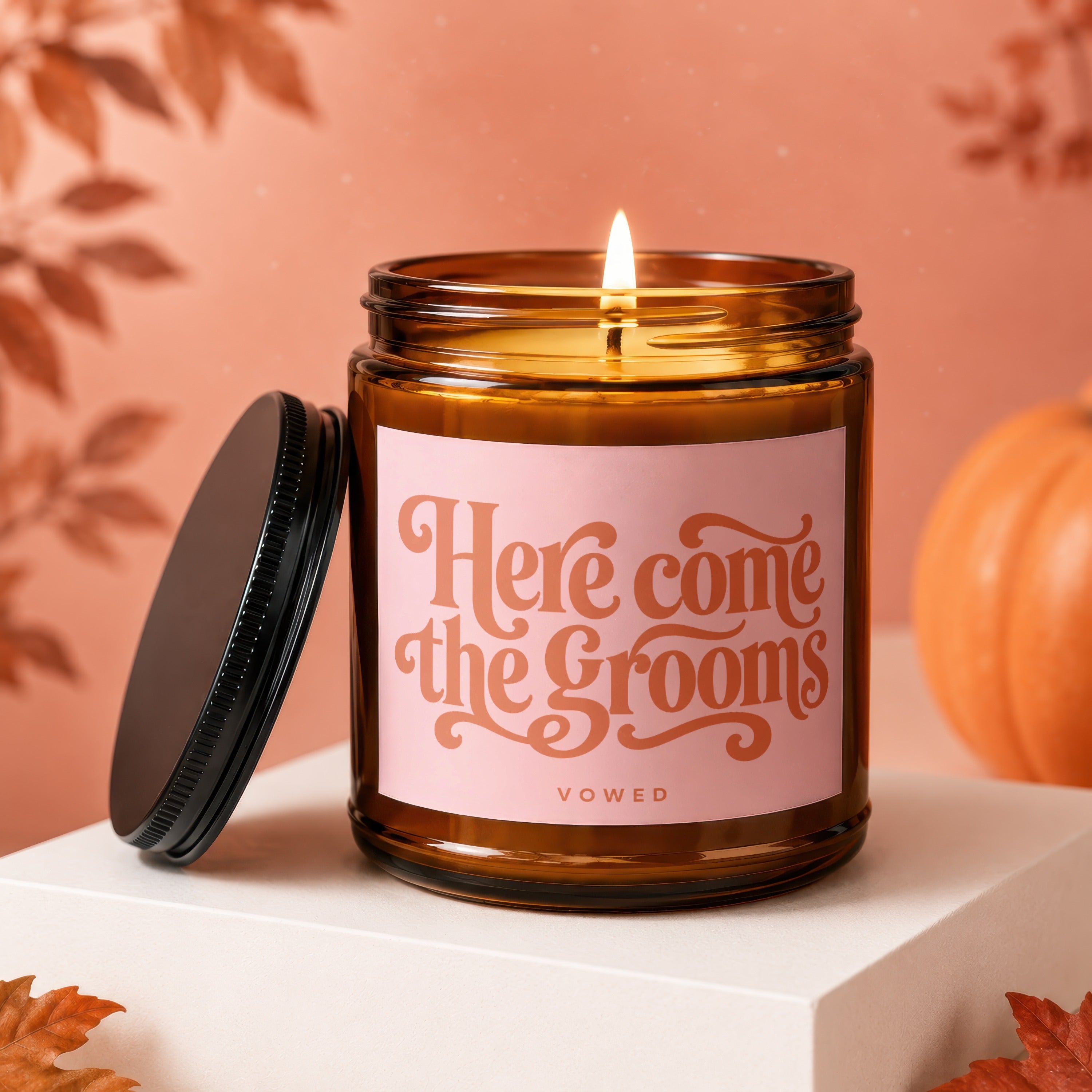 Amber candle with pink label that reads "Here come the Grooms" and "VOWED".