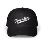 A black baseball cap featuring white embroidered script that reads Tipsy in Love on the front panel.