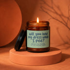 Amber jar candle with lid ajar, reads "will you hold my dress while I pee?".