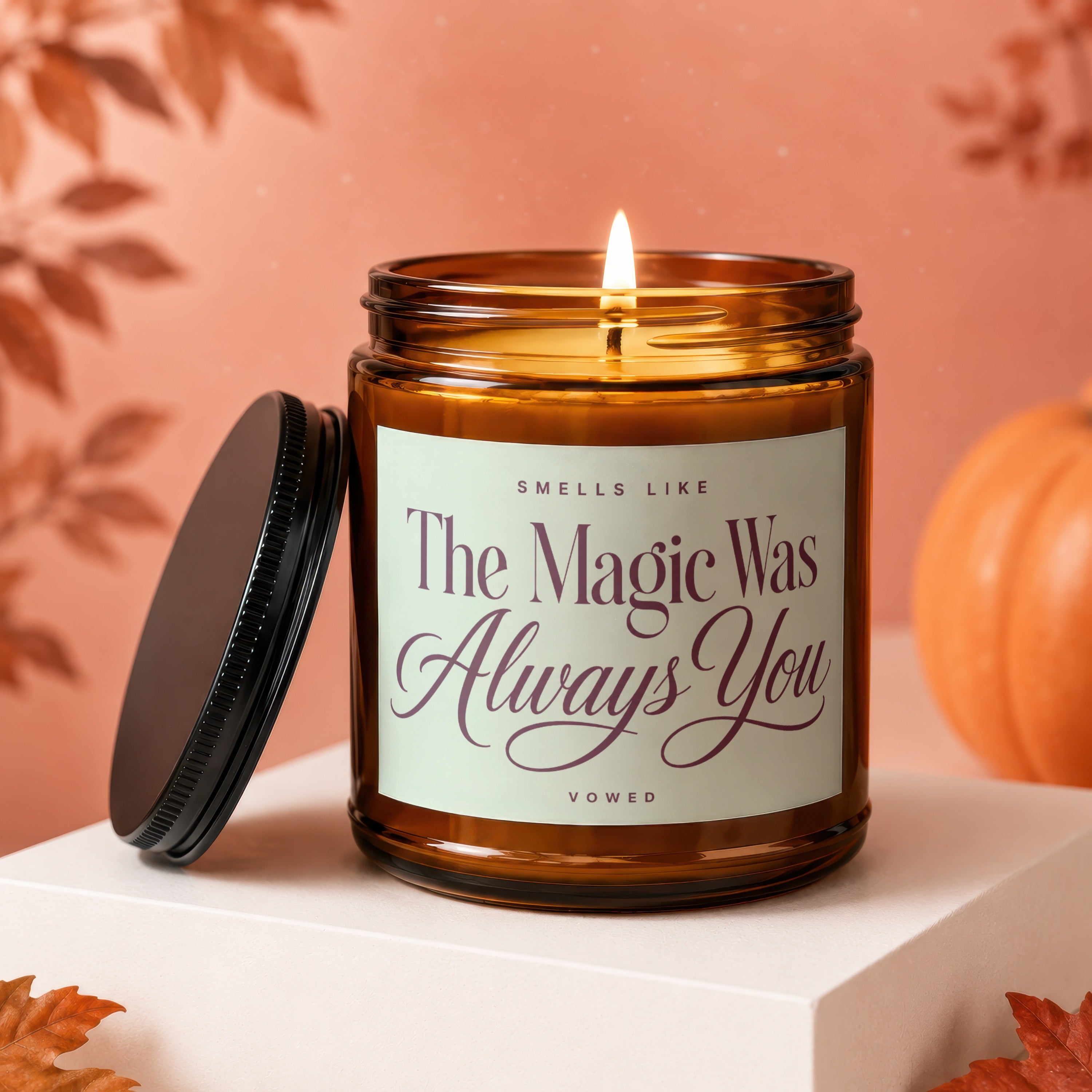 Amber jar candle with lit flame and text "The Magic Was Always You".