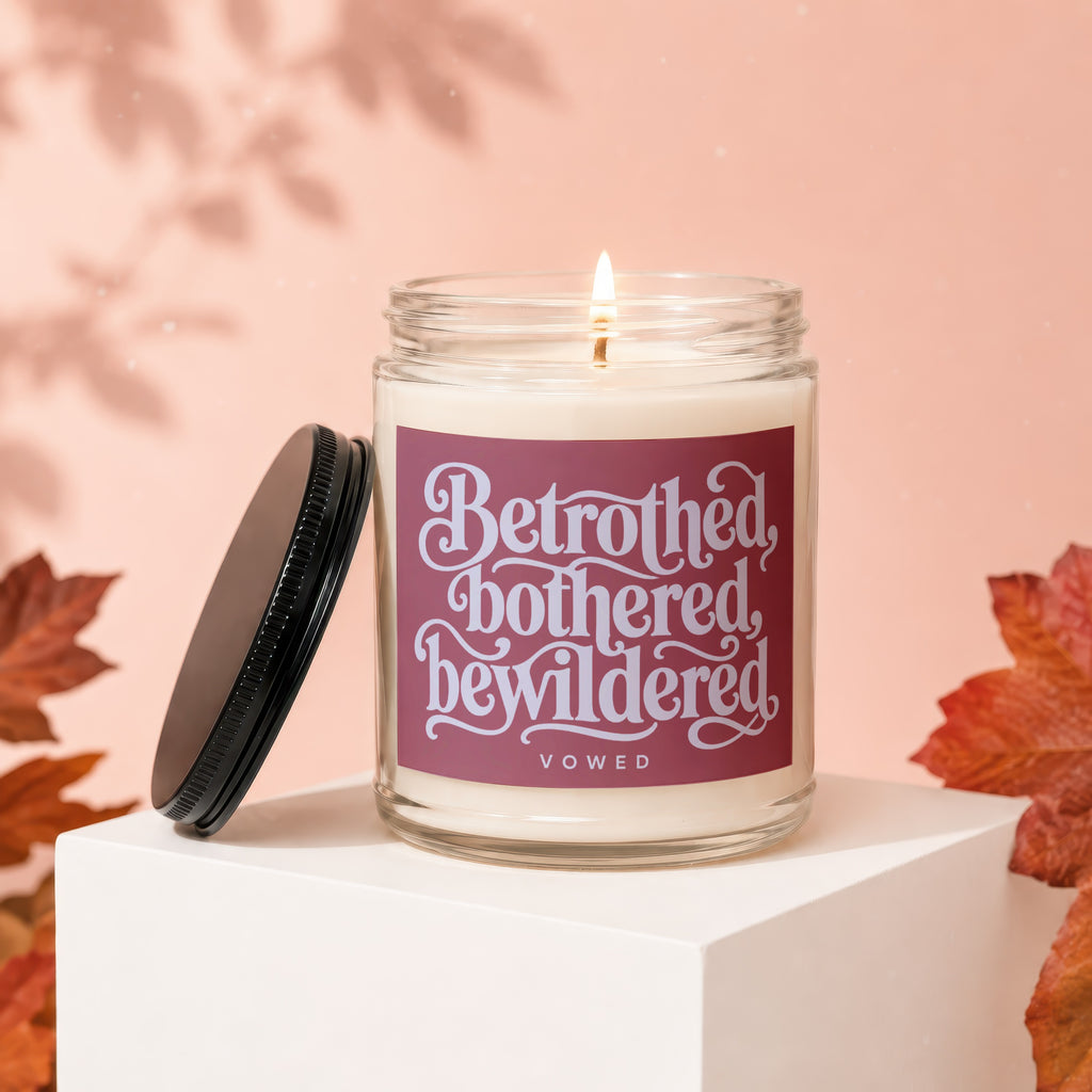 Jar candle with lid off, featuring the text "Betrothed, bothered, bewildered" and "vowed".