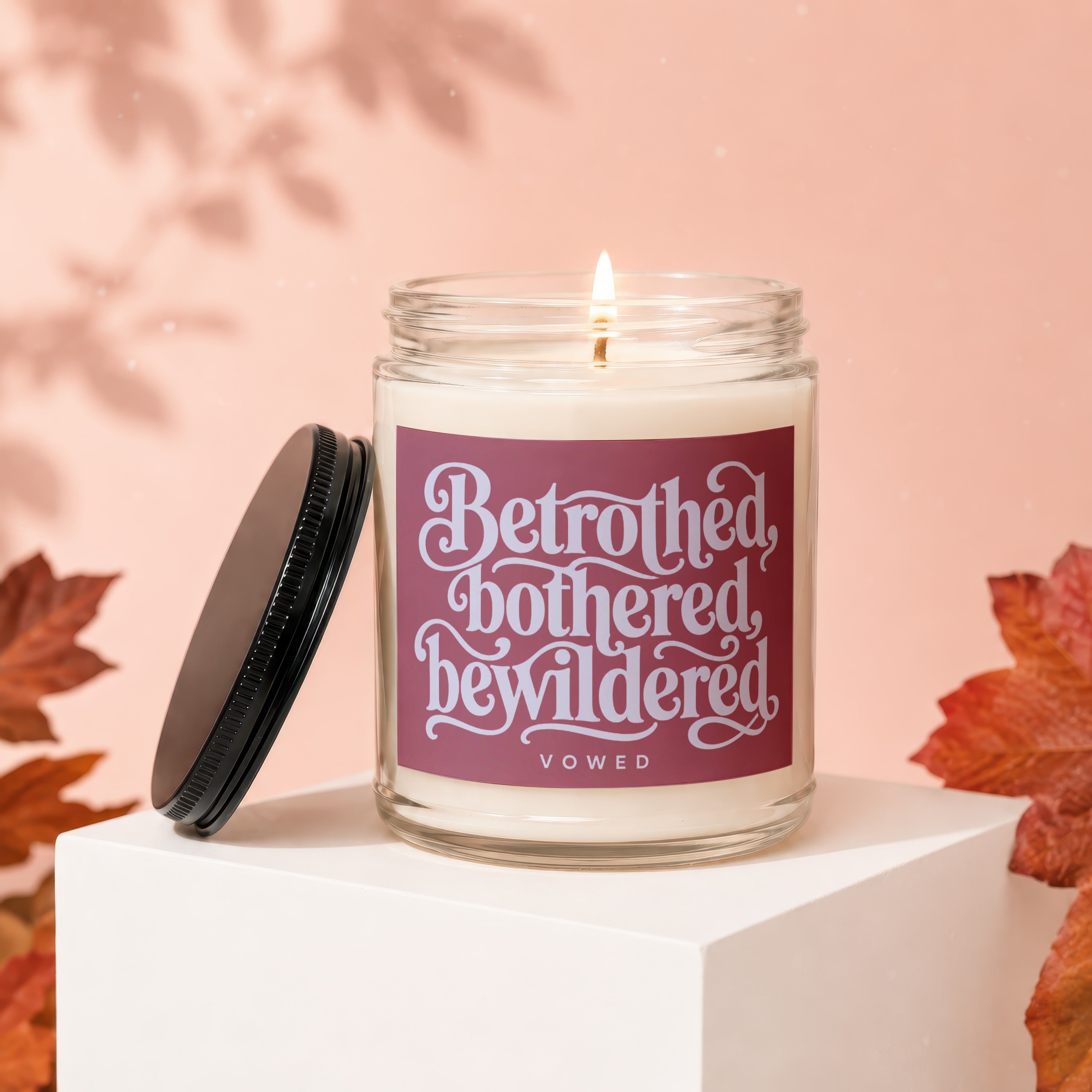 Jar candle with lid off, featuring the text "Betrothed, bothered, bewildered" and "vowed".
