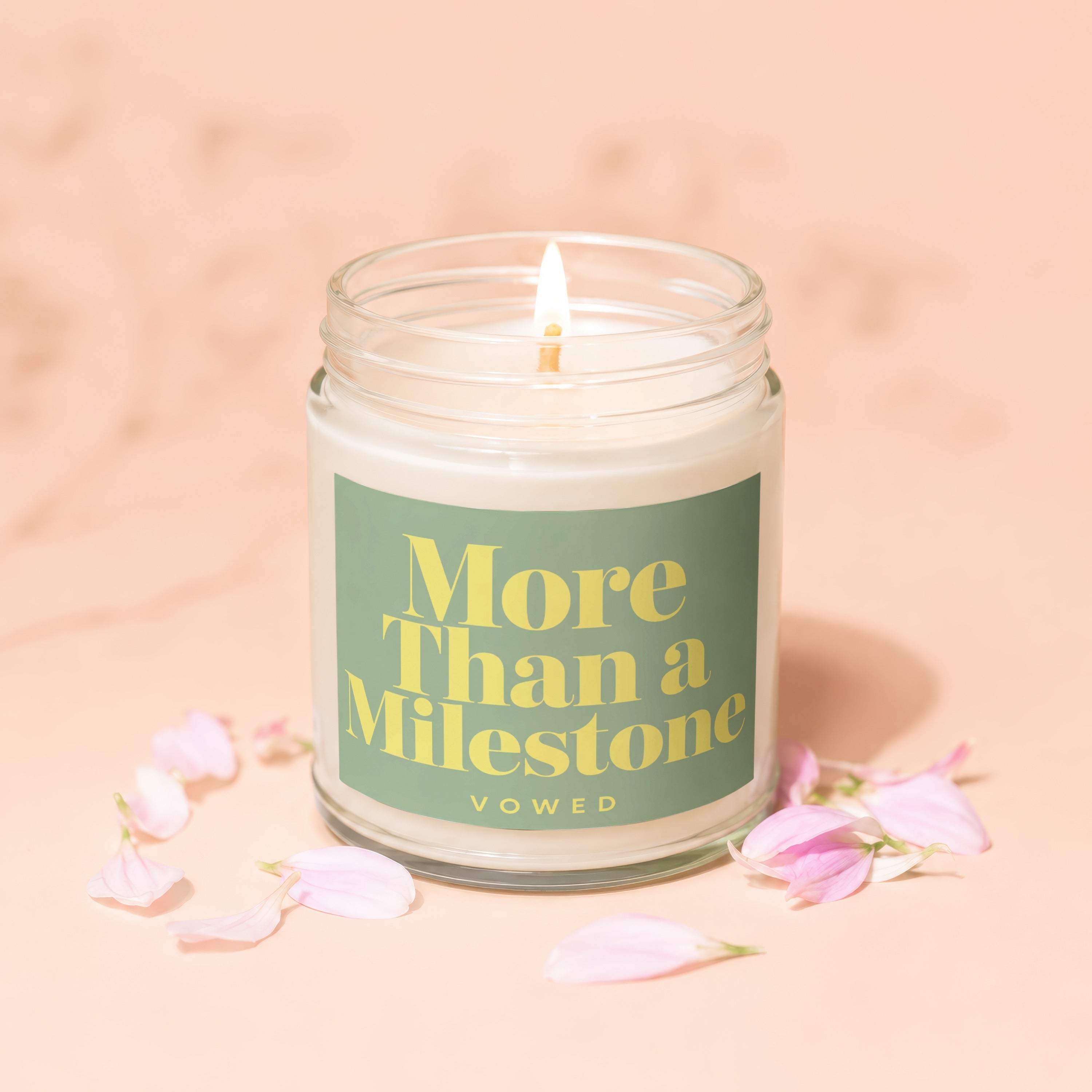 Candle with "More Than a Milestone" text under pink petals.
