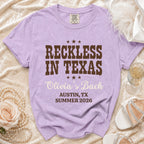 Purple Comfort Colors t-shirt with "Reckless in Texas" and Olivia's Bach text.