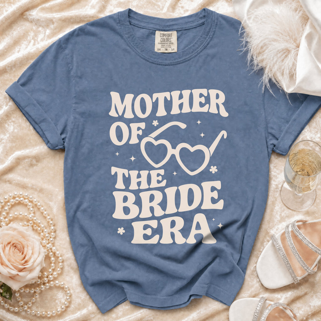 Blue t-shirt with "Mother of the Bride Era" and heart sunglasses graphic.