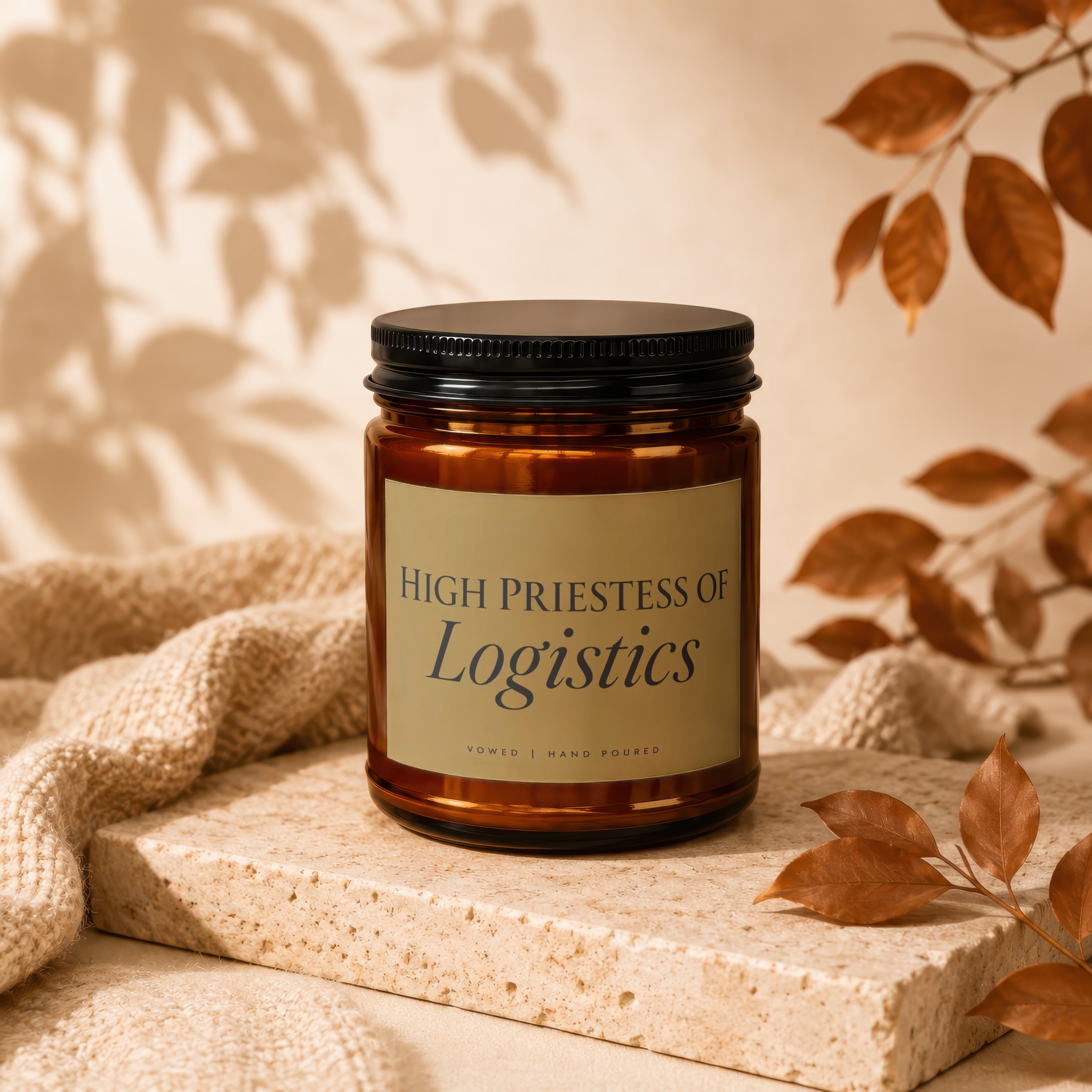 Amber glass candle with black lid, "High Priestess of Logistics" label.