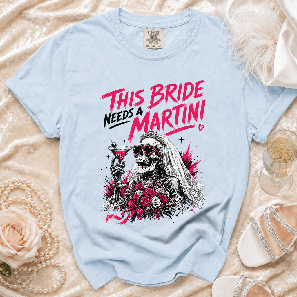 Light blue t-shirt with "This Bride Needs a Martini" graphic of a skeleton bride with a martini and roses.