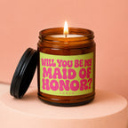 Amber jar candle with lit wick and lid off, reading "Will you be my Maid of Honor?"