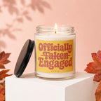 Candle with "Officially Taken Engaged" text, lit flame, and black lid.