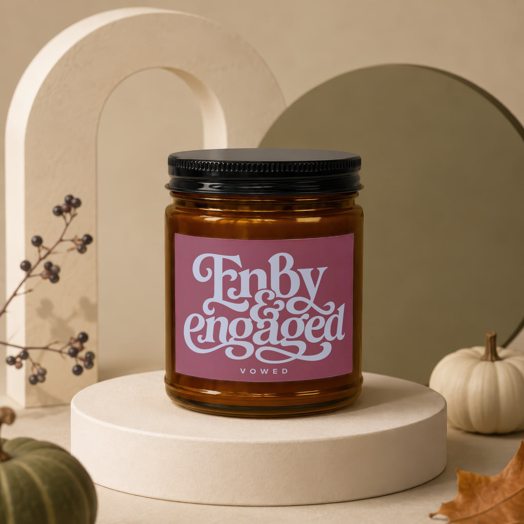 Amber candle with a pink label that says "Enby engaged VOWED".