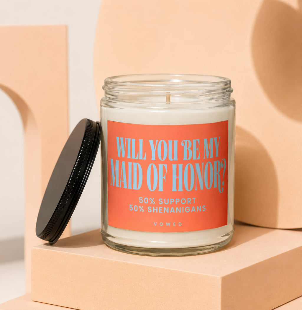 Glass candle with orange label asking "Will You Be My Maid of Honor?"