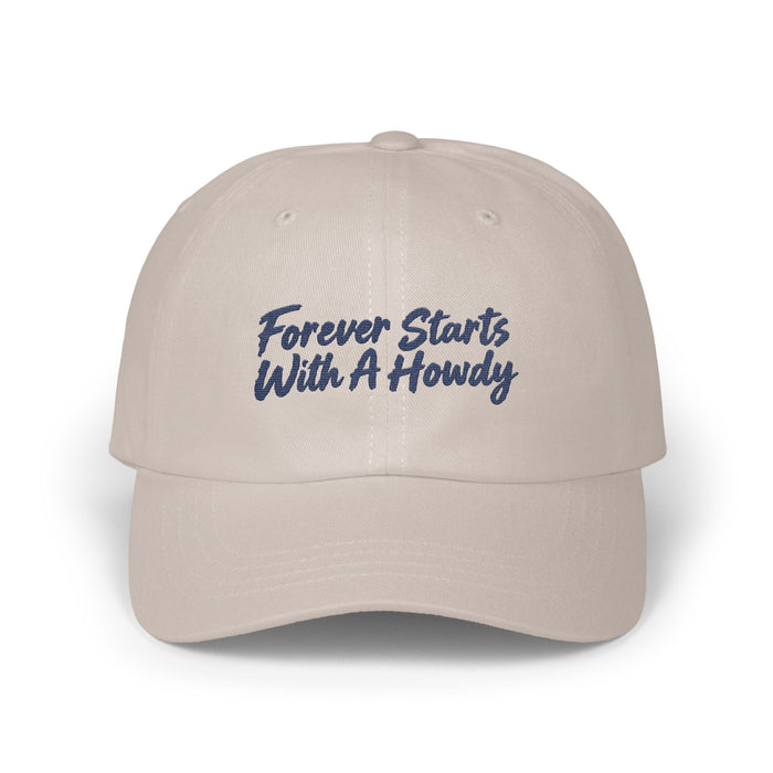 A light beige dad hat embroidered with blue cursive text reading Forever Starts With A Howdy.