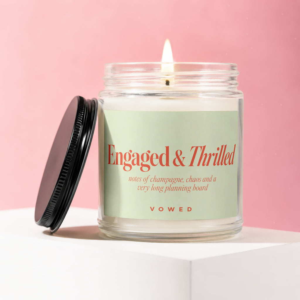 Jar candle with "Engaged & Thrilled" design in coral on a light green label.