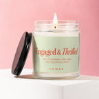 Jar candle with "Engaged & Thrilled" design in coral on a light green label.