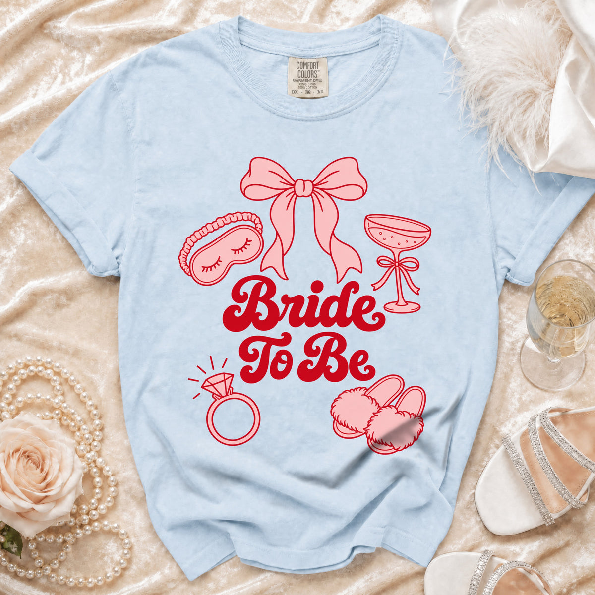 Light blue Comfort Colors t-shirt with "Bride To Be" and bridal icons in red.