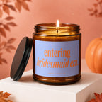 Amber candle with lit wick and purple label reading "entering bridesmaid era."