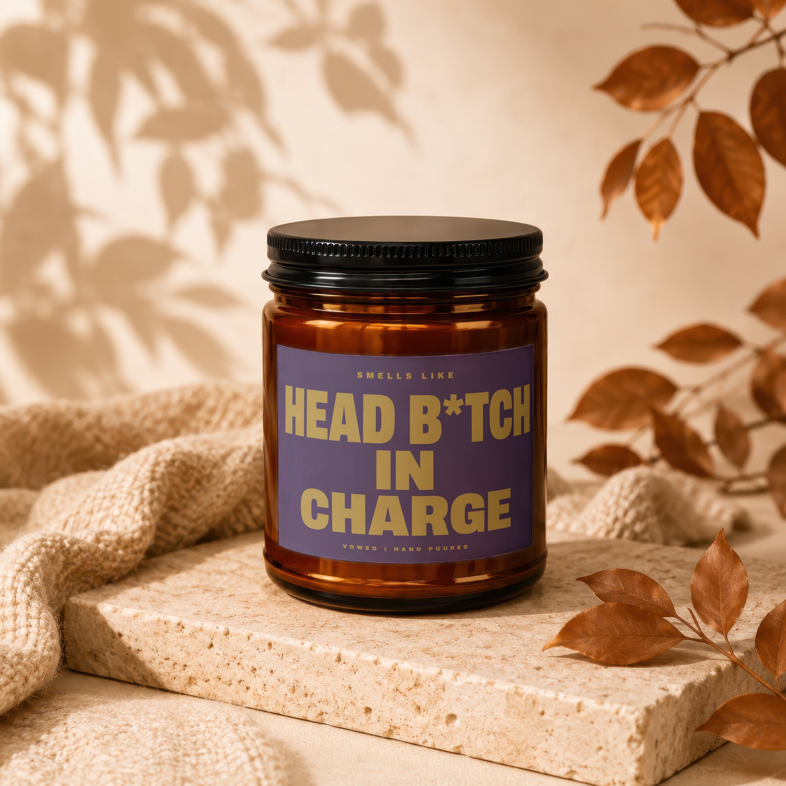 Brown glass candle with purple label reading "Head B*tch In Charge".