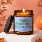 Brown glass candle with lit flame and the text "I Fluffed Your Dress. You're Welcome."