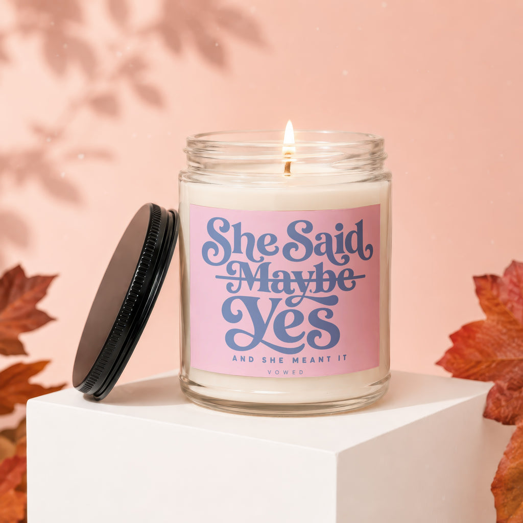 Candle with pink label reading "She Said Maybe Yes And She Meant It"