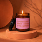 Amber glass candle labeled "Professional Dress Fluffer Bridesmaid" on a circular stand.