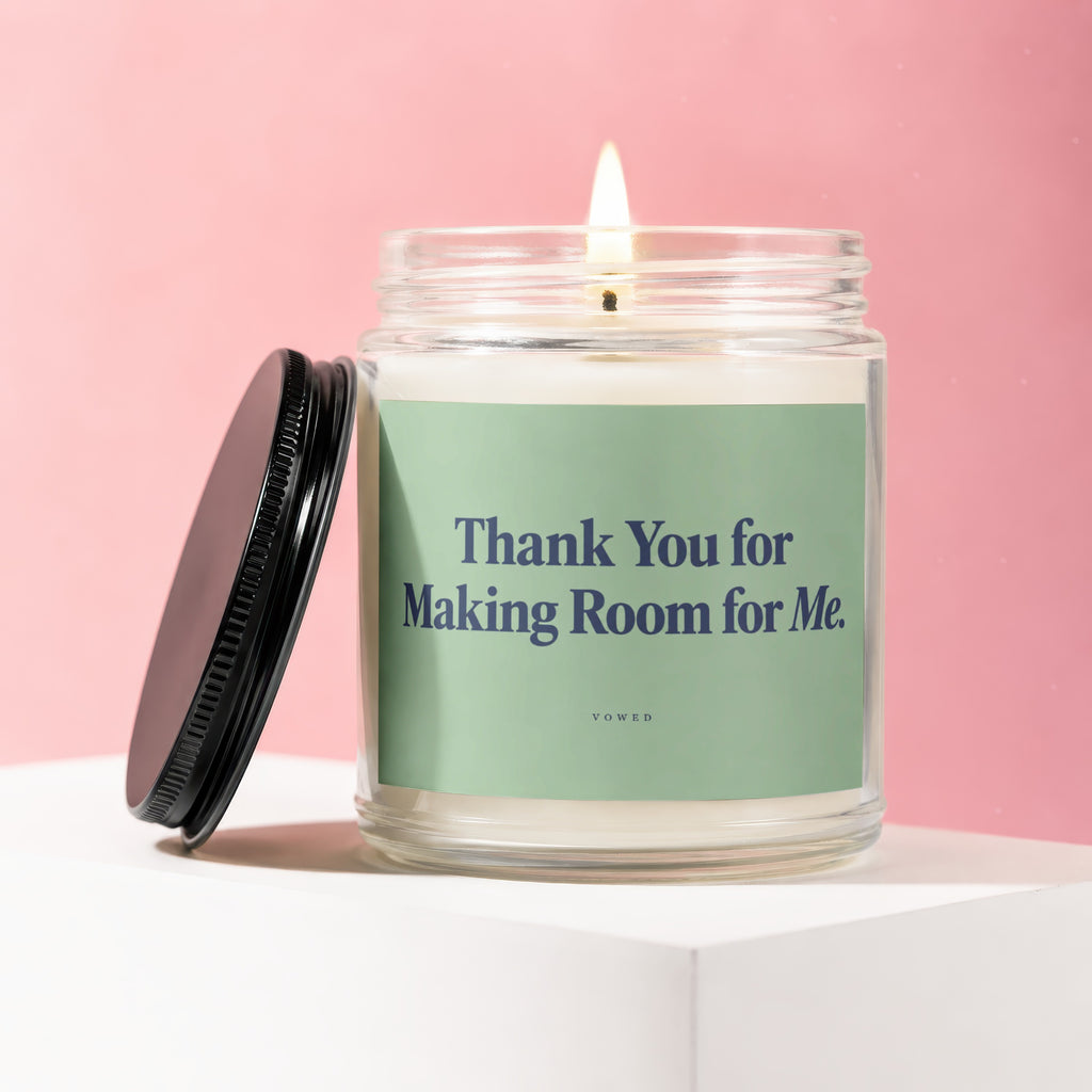 Lit candle in a glass jar with a green label saying "Thank You for Making Room for Me."