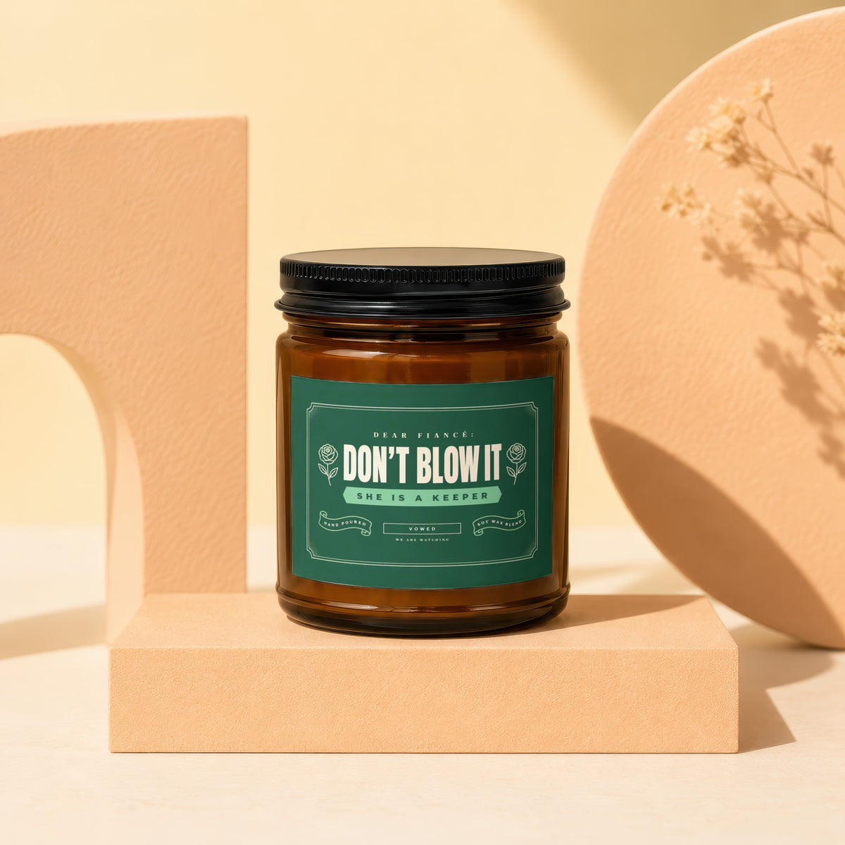 Brown jar candle with green label reading "Dear Fiancé: Don't Blow It."