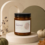 Amber jar candle with "here's to forever, newly engaged" text and leaf design.