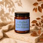 Amber jar candle with blue label reading "I Fluffed Your Dress. You're Welcome." Vowed.