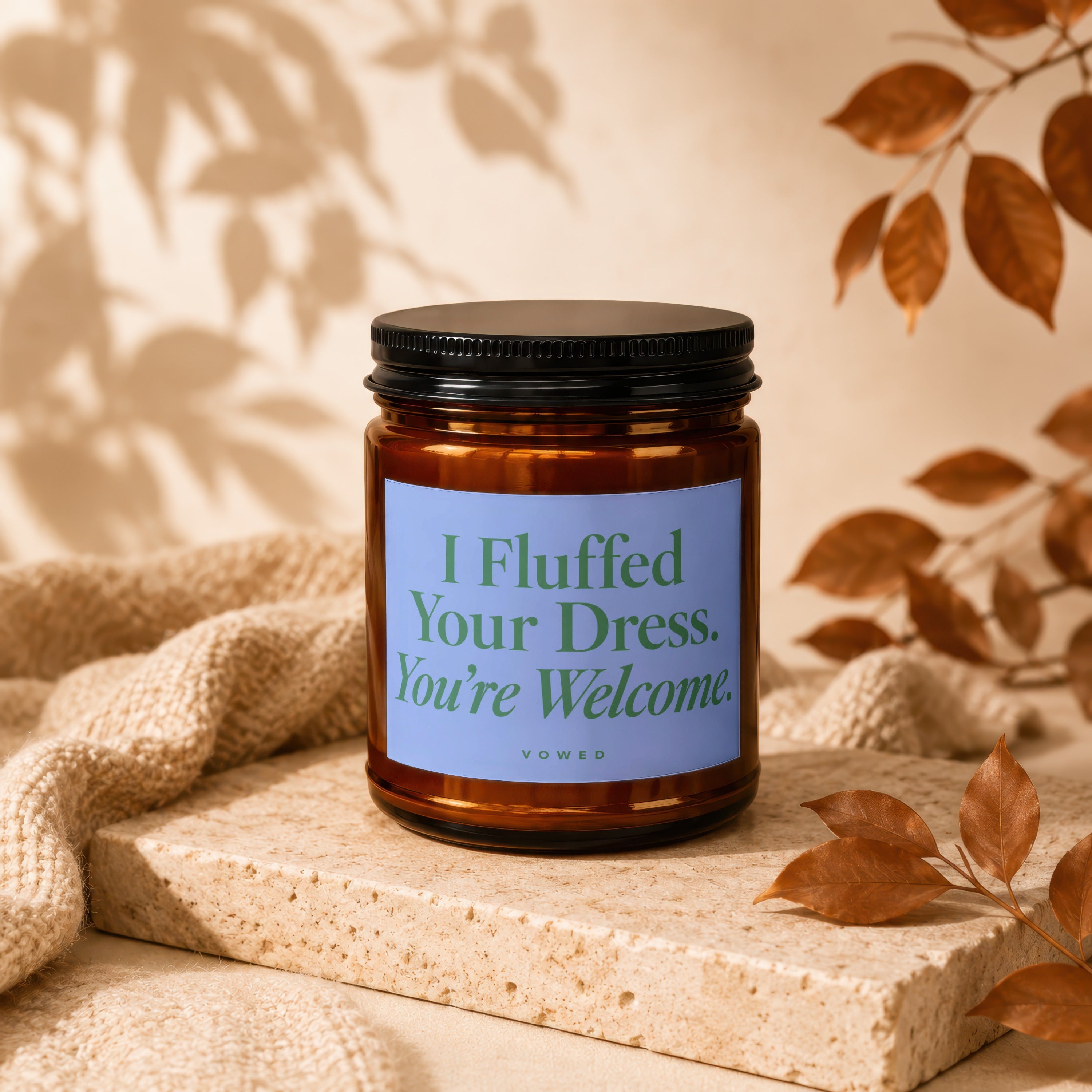 Amber jar candle with blue label reading "I Fluffed Your Dress. You're Welcome." Vowed.